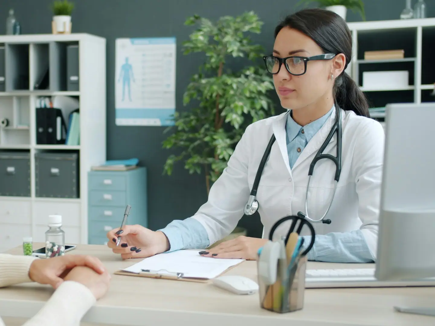 A doctor talking with a patient at her desk