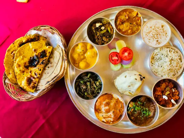A large platter of curries, rice, flatbreads and fresh sides